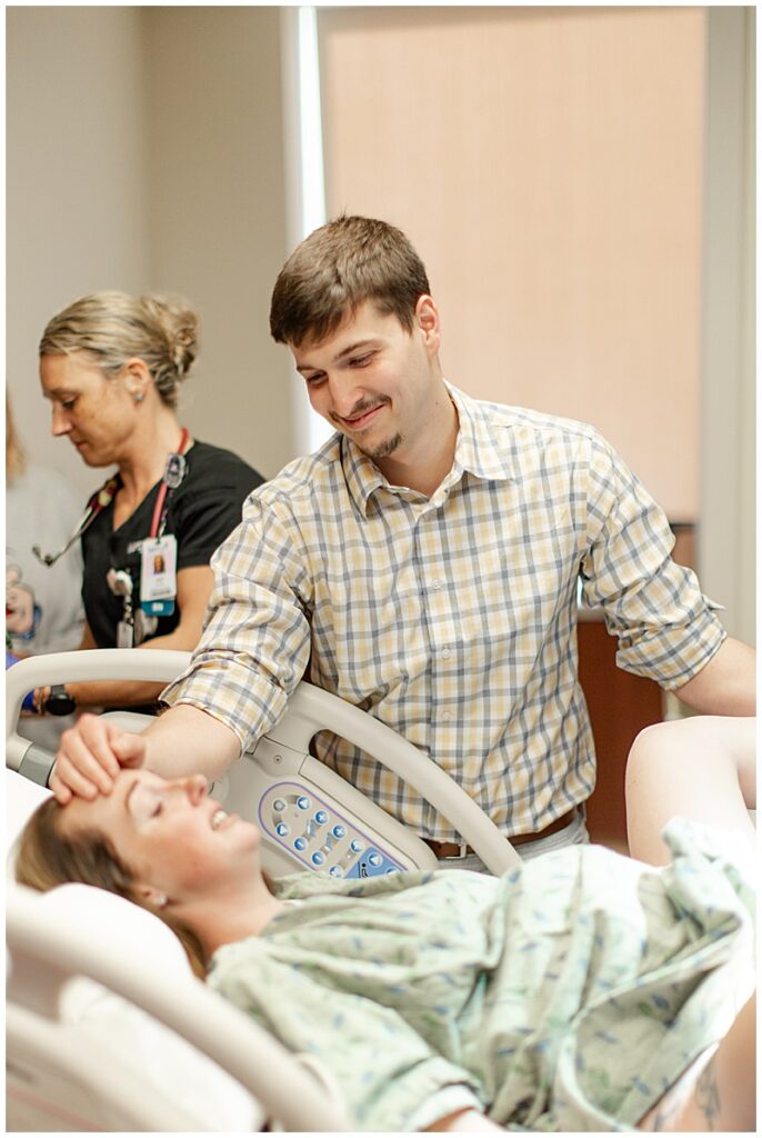 Supportive partner is rubbing wife's head while she is in labor