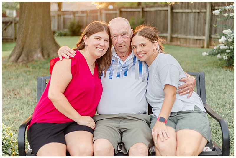 Grandfather holding his granddaughters for a special portrait, capturing their close bond.