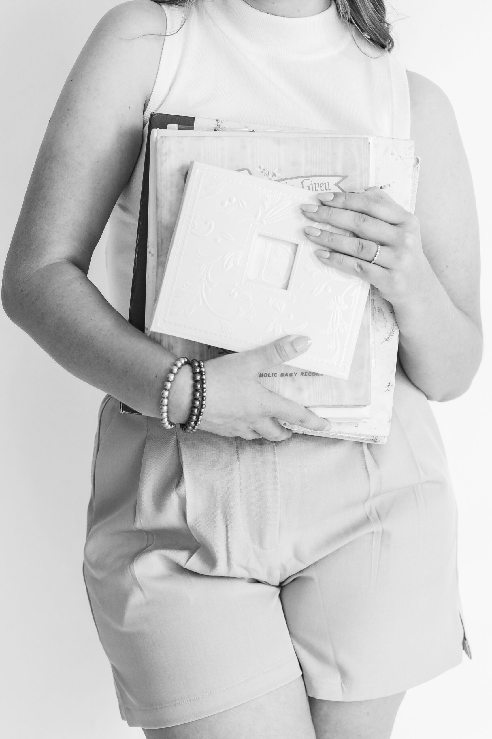 Close up of woman holding multiple photo albums
